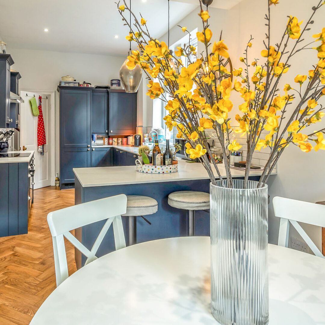 Vase of yellow spring flowers on a kitchen table