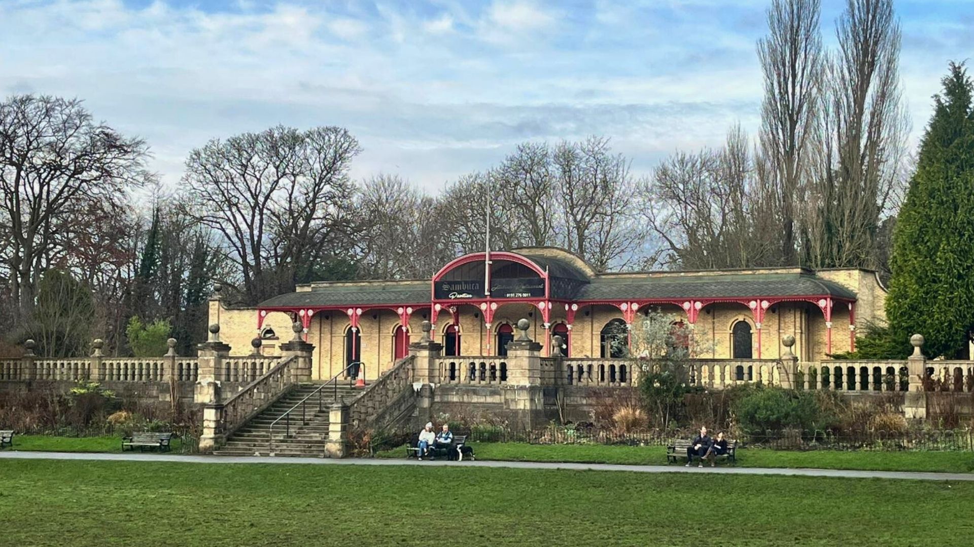 Heaton Pavilion in Newcastle, a historic park building with arched walkway, aet within green parkland and trees.