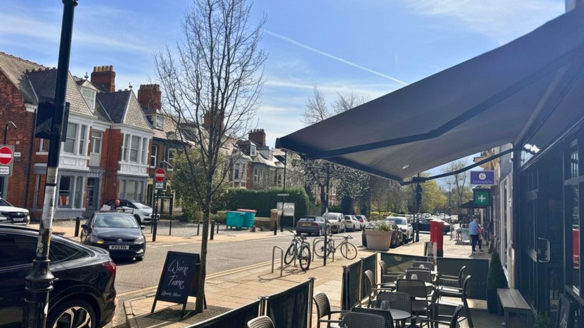 St George's Terrace in Jesmond street scene with the view of a cafe, bicycles and cars.